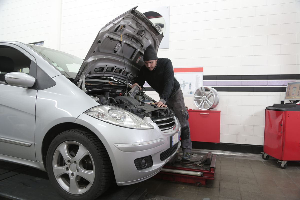 Mechaniker prüft ein angehobenes Fahrzeug