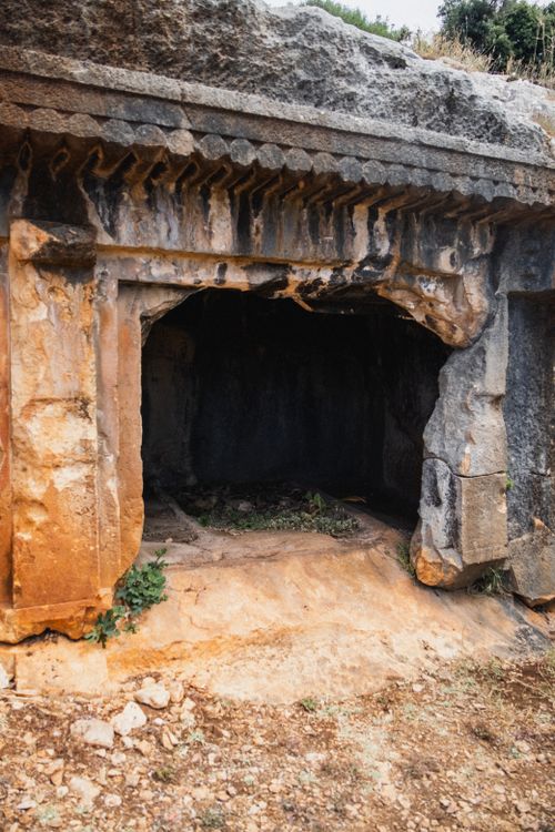 Free Ancient rock-cut tomb with weathered stone entrance, rich in history. Stock Photo