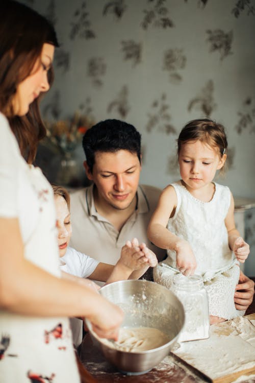 Photo of Woman Baking Near Her Family