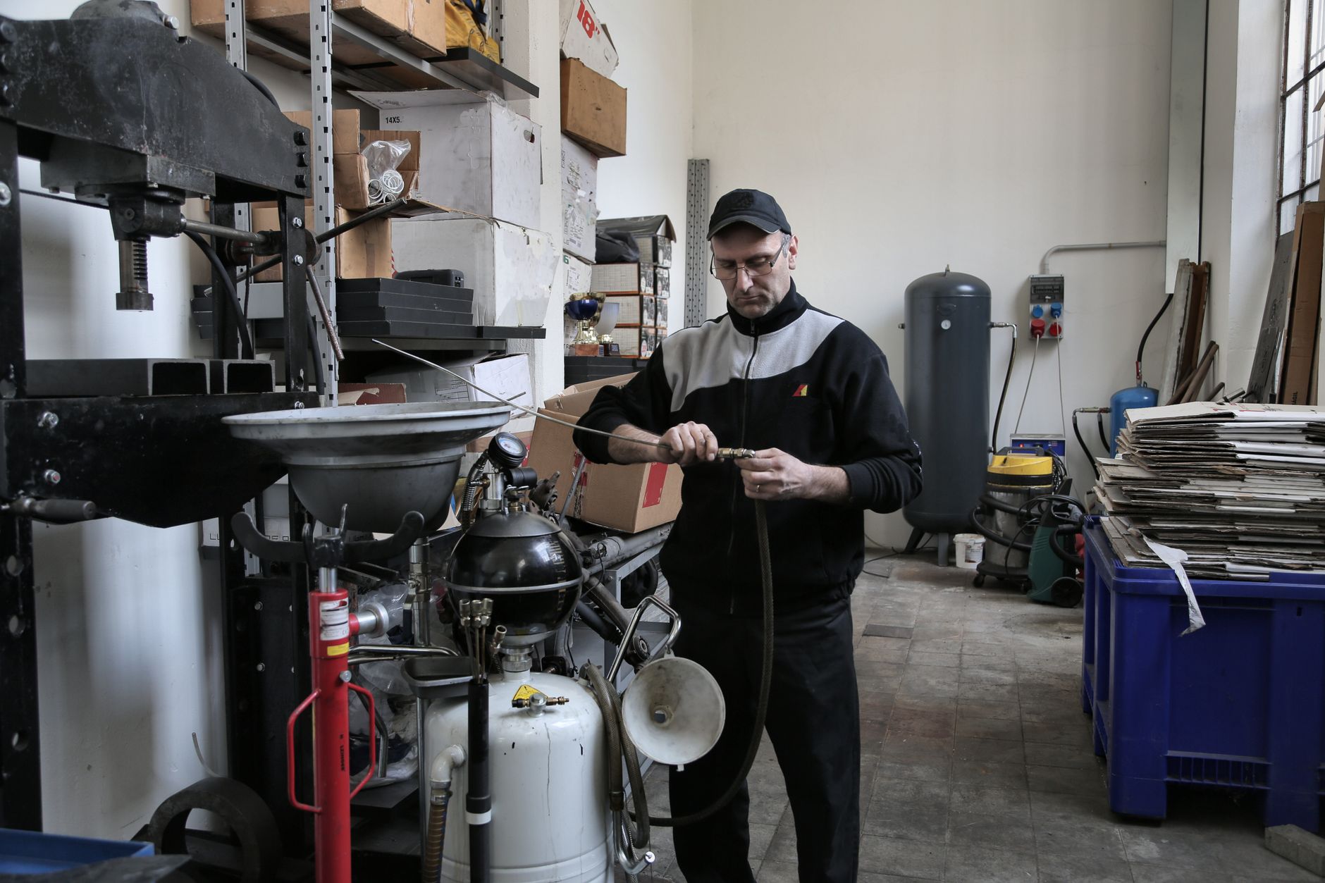 Troubleshooting Shearing Machine Hydraulic Problems插图1 Serious adult mechanic in black uniform fixing compressor tube while working in professional workshop