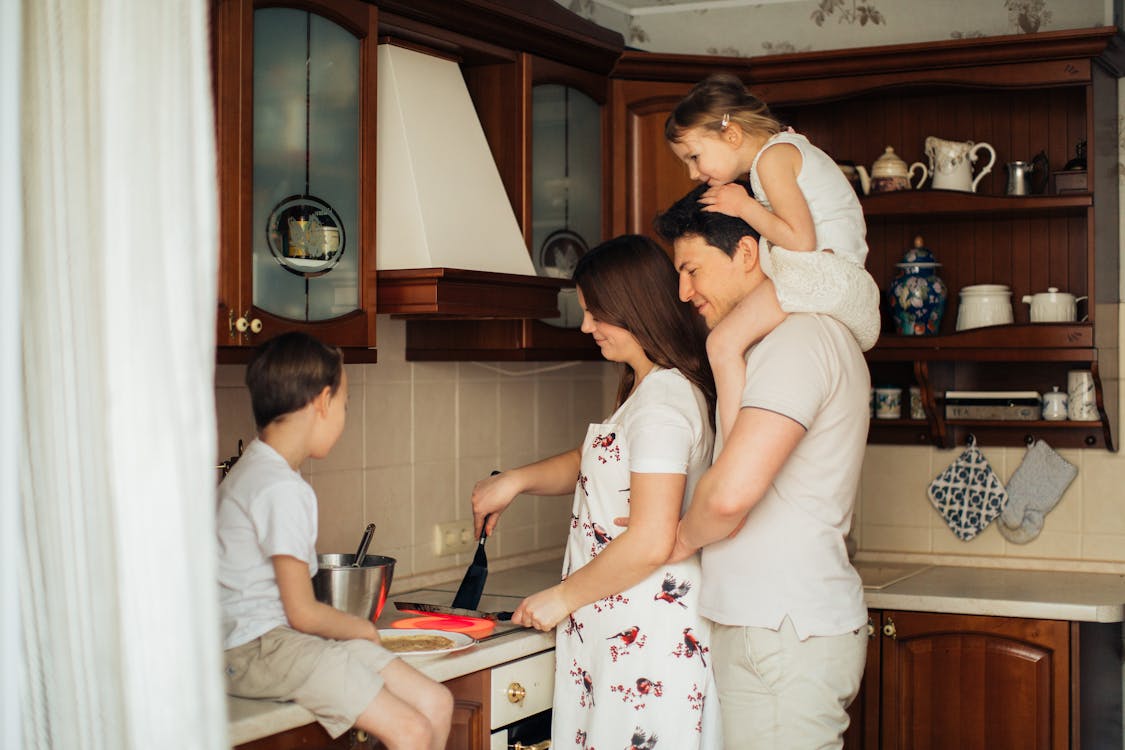 Photo of Woman Cooking Near Her Family