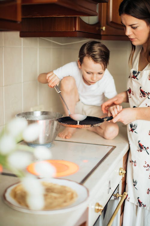 Photo of Woman Teaching Her Kid on how to Cook