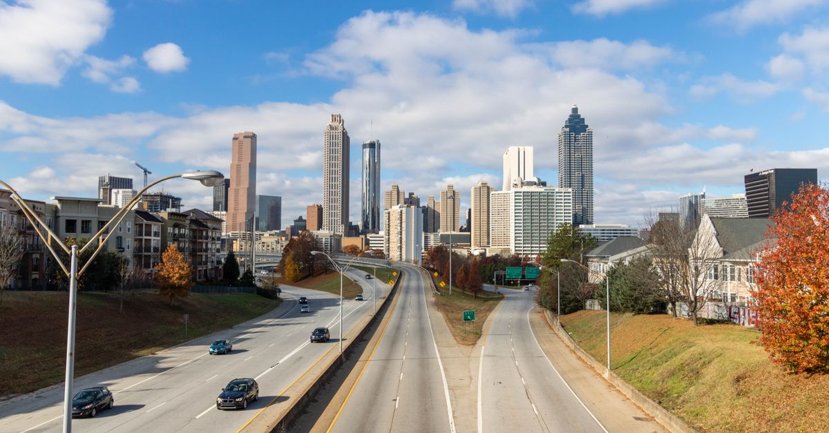 A clear view of the Atlanta skyline with highways leading into the city on a sunny day.