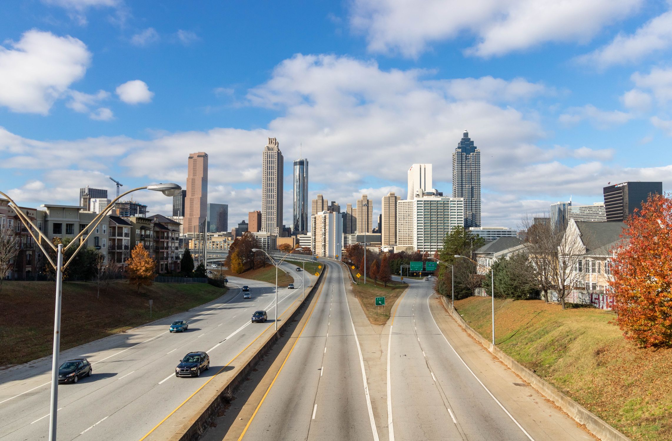 A clear view of the Atlanta skyline with highways leading into the city on a sunny day.
