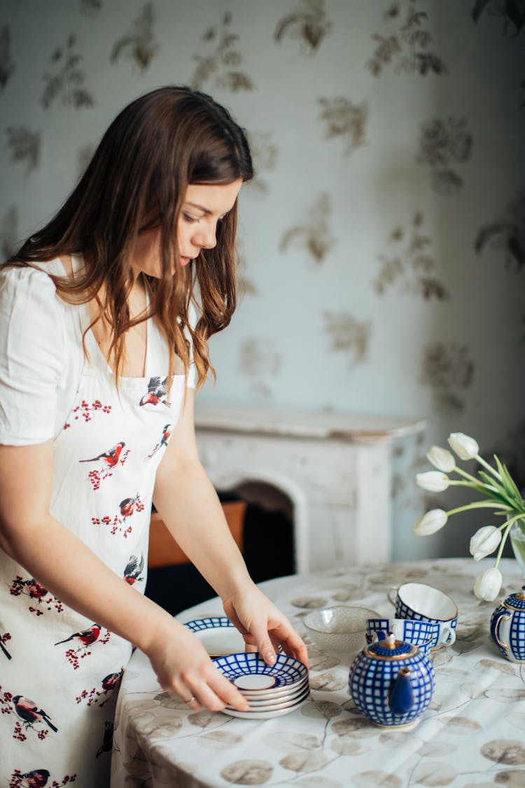 Photo Of Woman Setting Up The Table