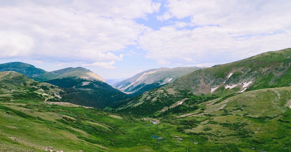 Breathtaking summer view of the lush green valleys and majestic peaks of Colorado's Rocky Mountains.