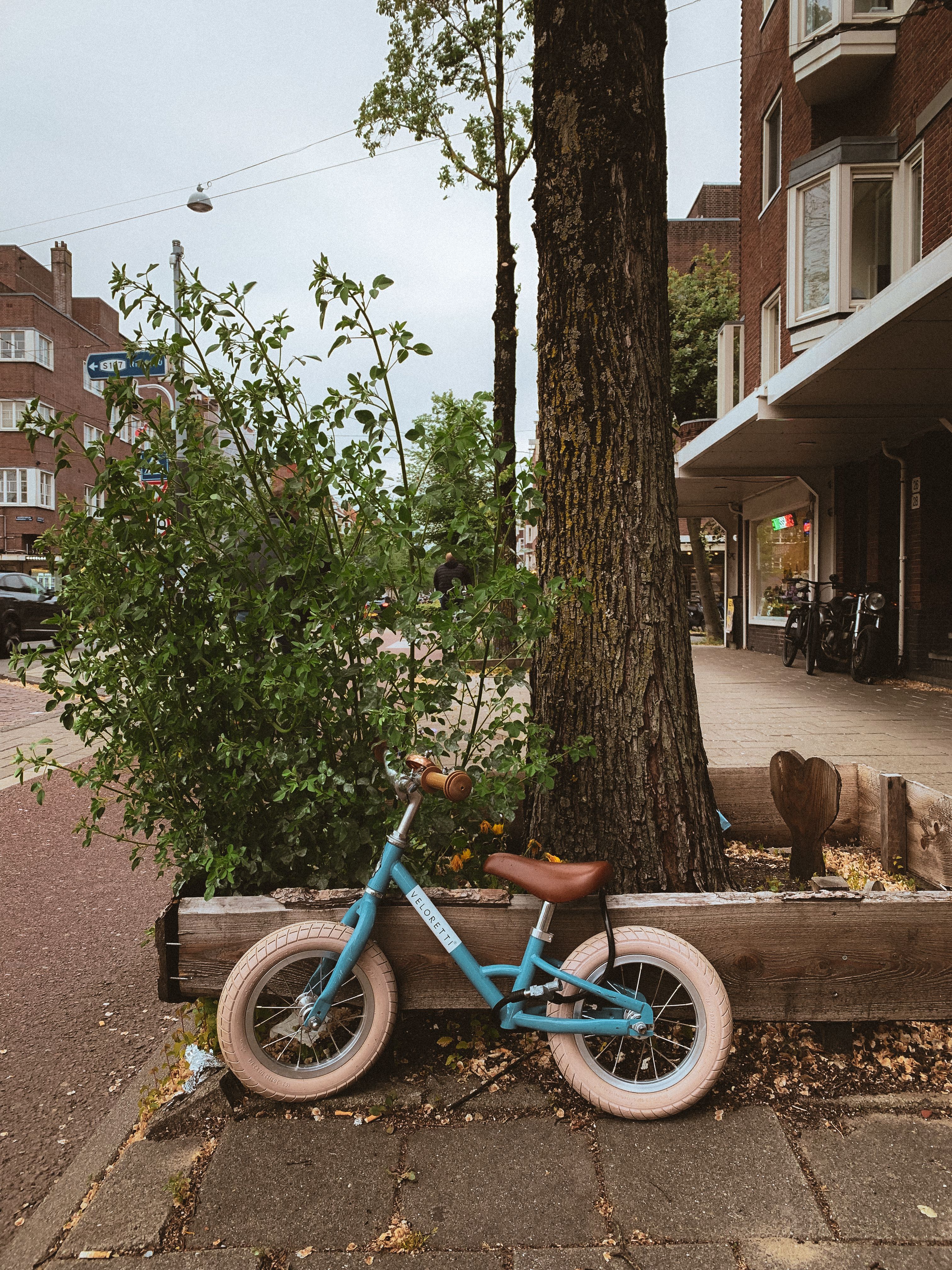 kinderen fietsen samen op verschillende maten fietsen in woonwijk