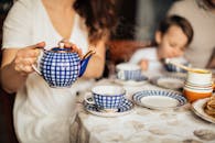 早餐场景舒适惬意，配有蓝色图案的茶壶和杯子，家人正享用着早茶