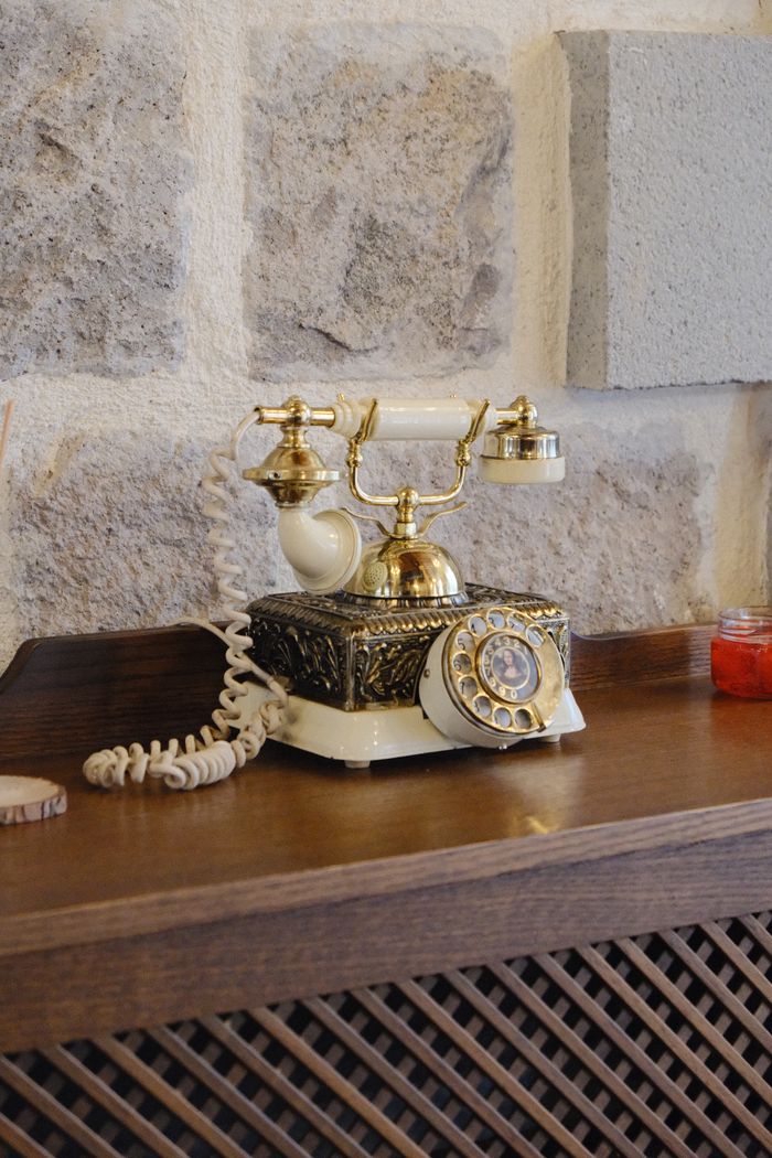 Antique rotary telephone on a wooden console — photo by bet&uuml;l nur aky&uuml;rek on Pexels