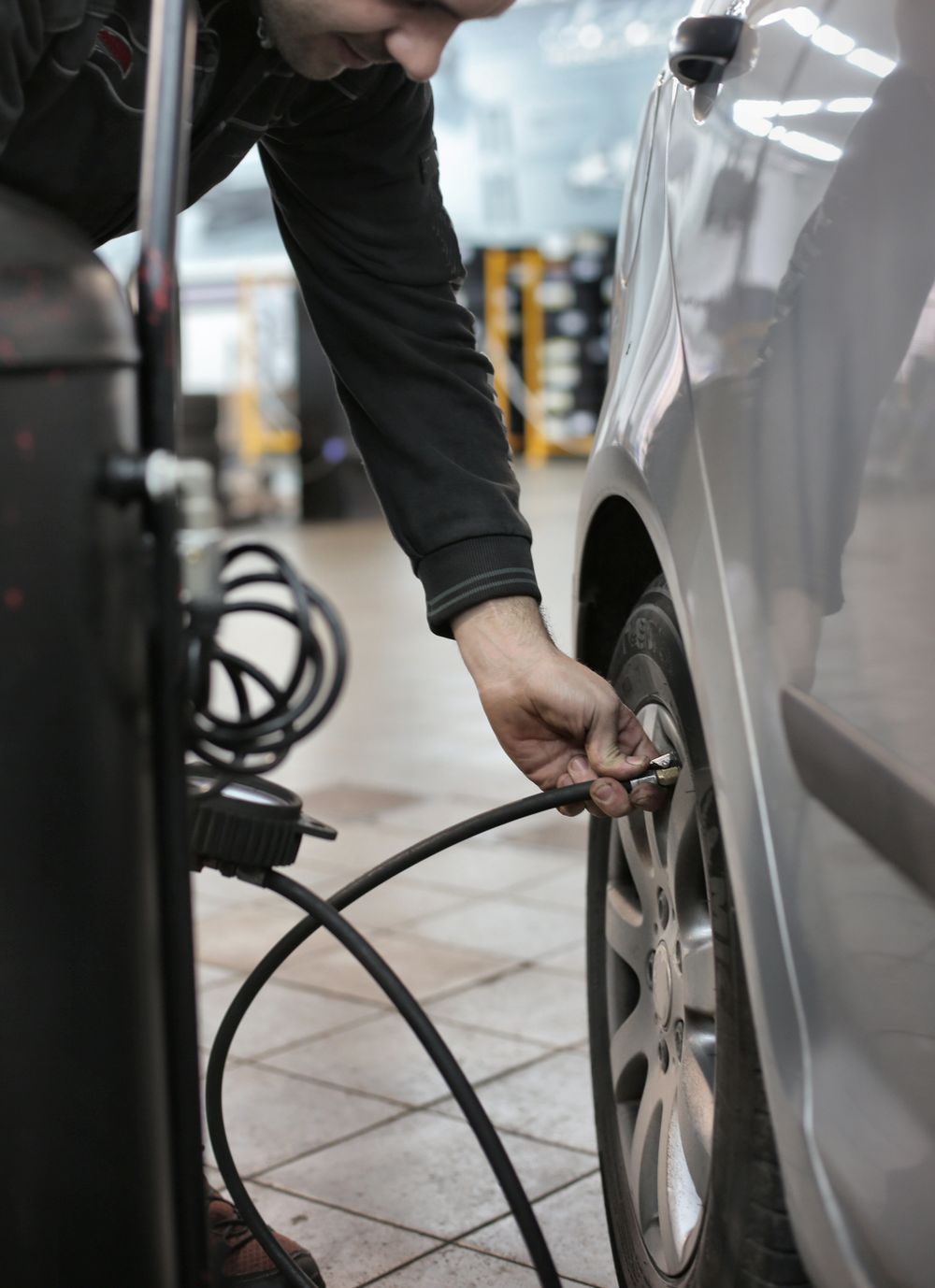 Mechanic checking tire pressure in a service bay