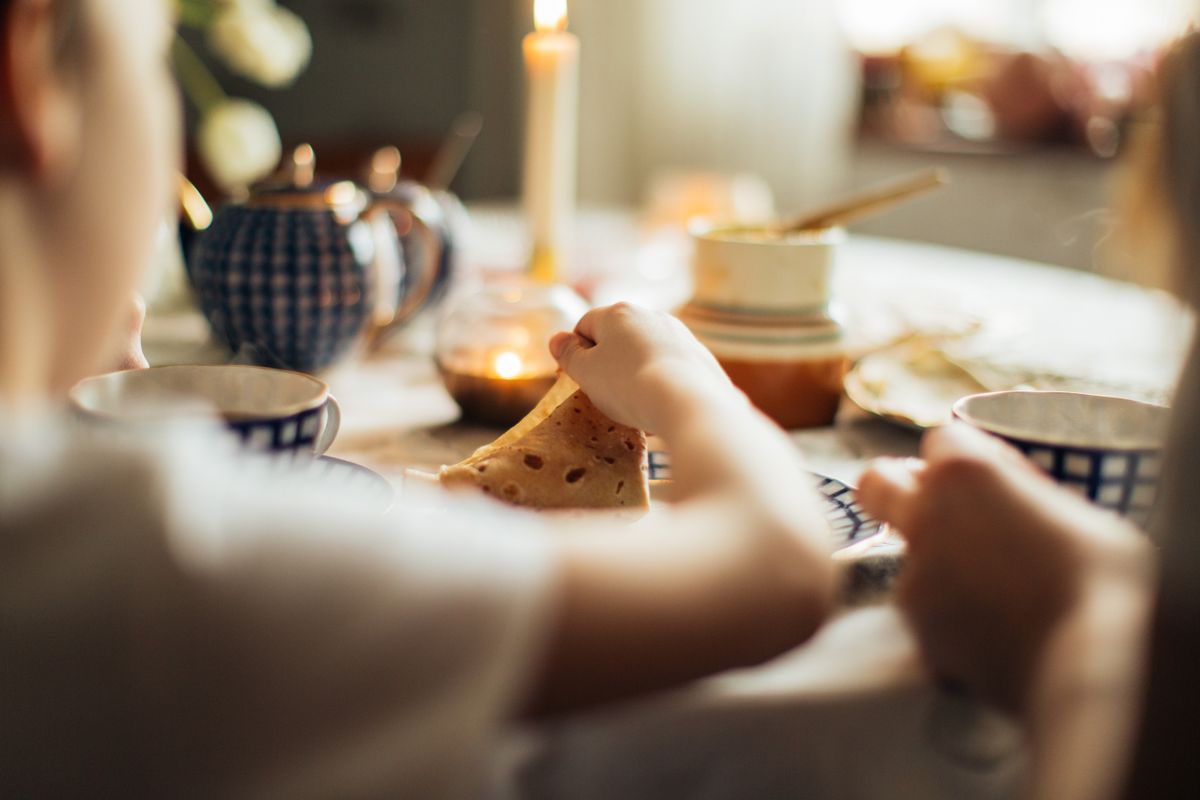 Table chaleureuse avec pâtisseries artisanales, bougie et lumière douce du matin