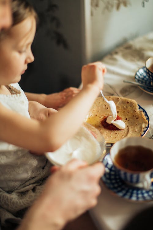 Child decorating her pancake on Pancake Day