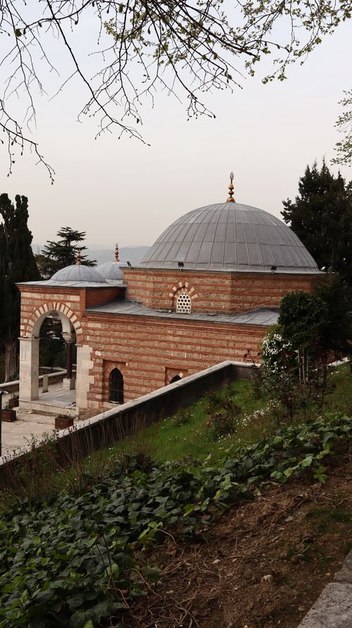 Free View of historic Ottoman mosque in Bursa, Türkiye surrounded by lush greenery. Stock Photo