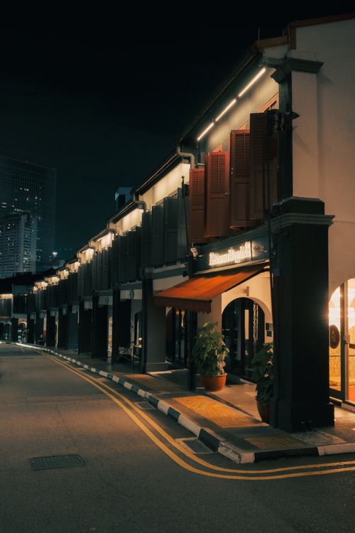 Free A quiet street at night with illuminated historic architecture and ambient lighting. Stock Photo