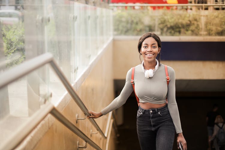 Woman Smiling While Holding To Handrail