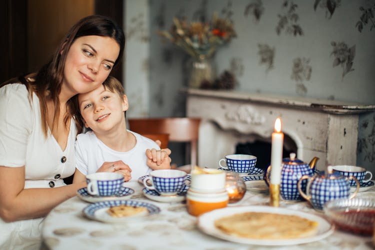 Happy Mother And Son Having Breakfast At Home