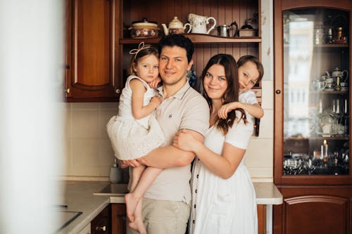 Free Cheerful family standing together at kitchen Stock Photo
