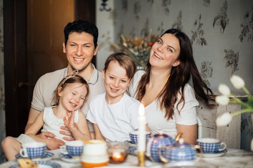 Familia Amorosa Riendo En La Mesa Con Comida Acogedora