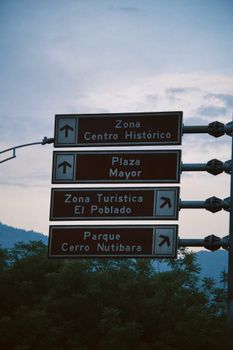 Street signs in Medellín point to Zona Centro Histórico and El Poblado.