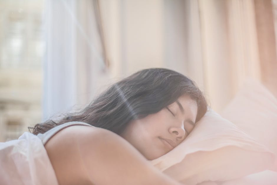 Layla Hybrid vs Idle Sleep: Flippable Firmness Showdown Portrait of a woman sleeping peacefully in soft morning light indoors.