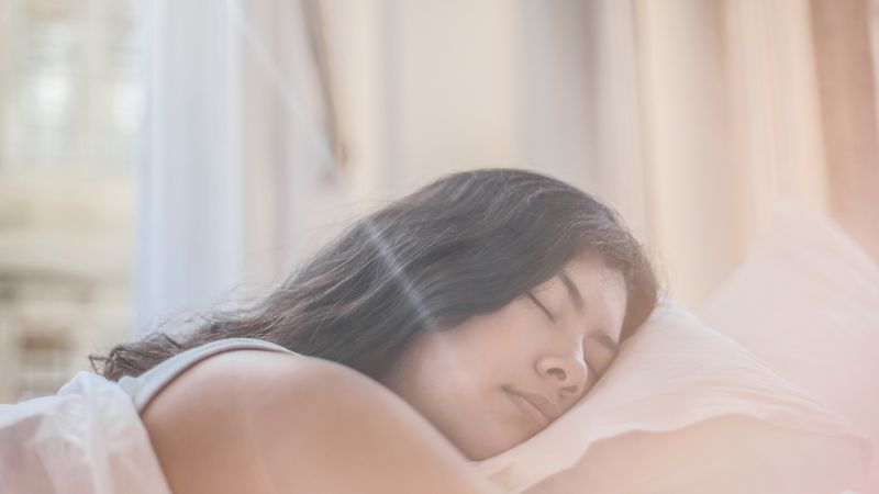 Woman sleeping peacefully in soft morning light, the kind of outcome the best CBD for sleep aims to support