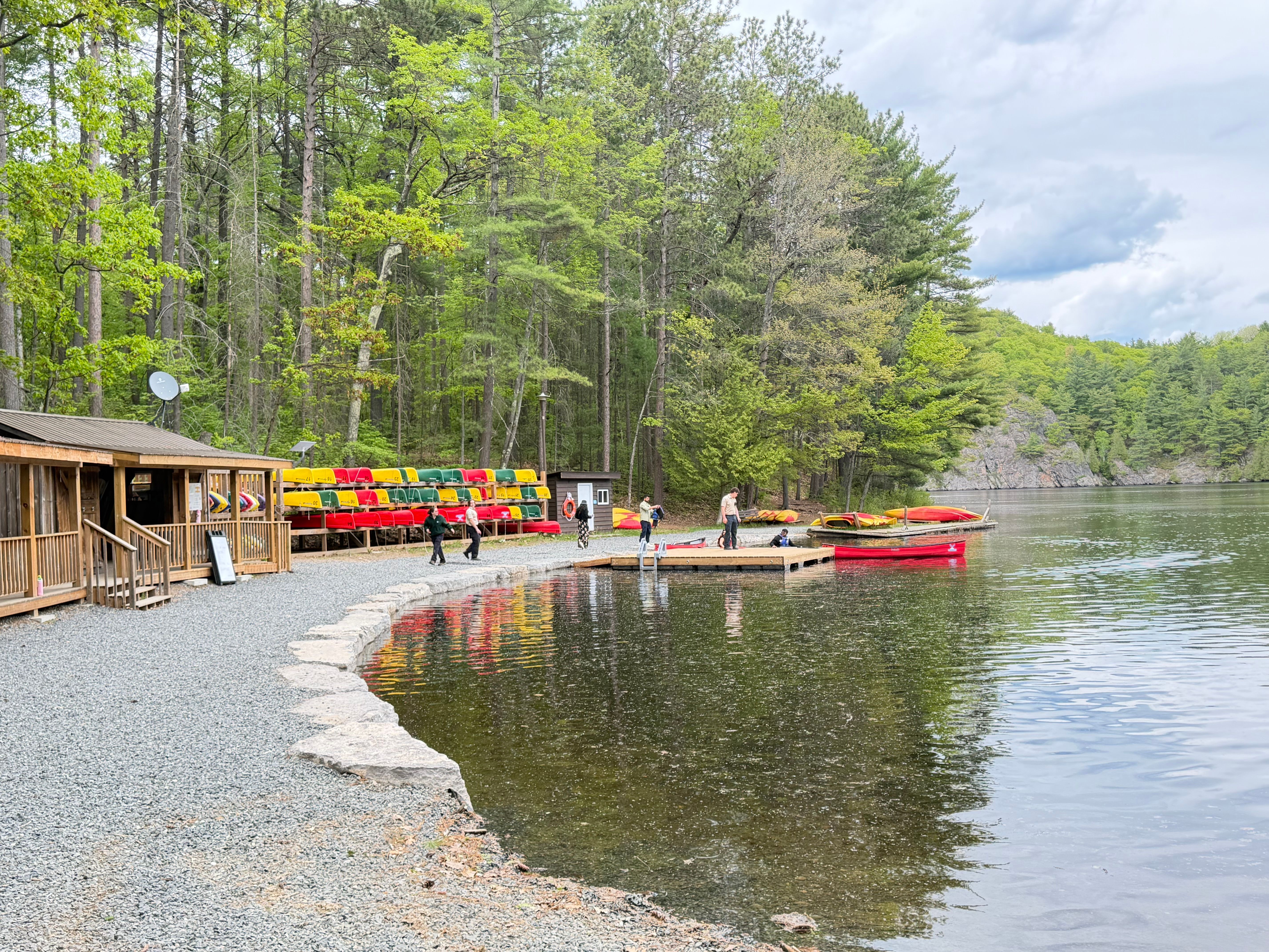 A scenic view of a canoe dock in a lush lakeside forest, perfect for outdoor activities.