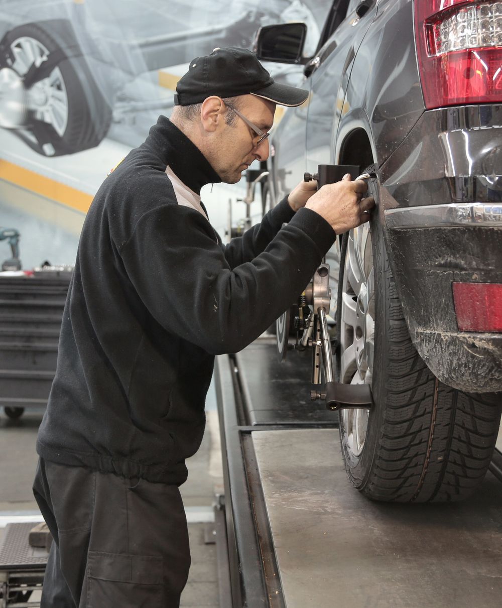 Wheel alignment work in automotive workshop