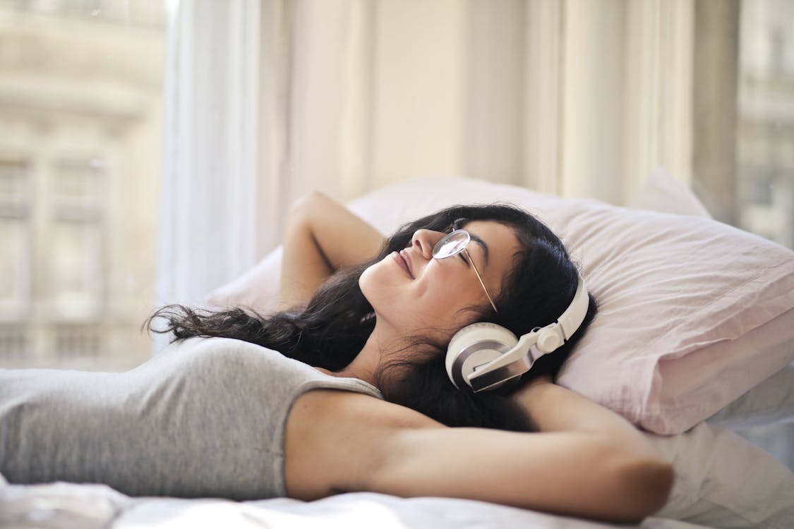  Woman in Gray Tank Top Listening to Music