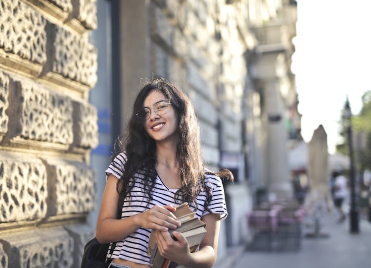 Woman In Black And White Stripe Shirt Holding Books