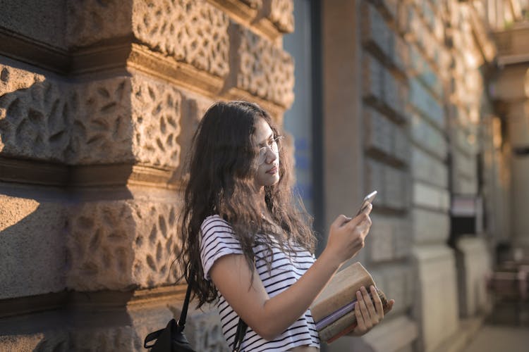 Woman In Black And White Striped Shirt Leaning On Wall