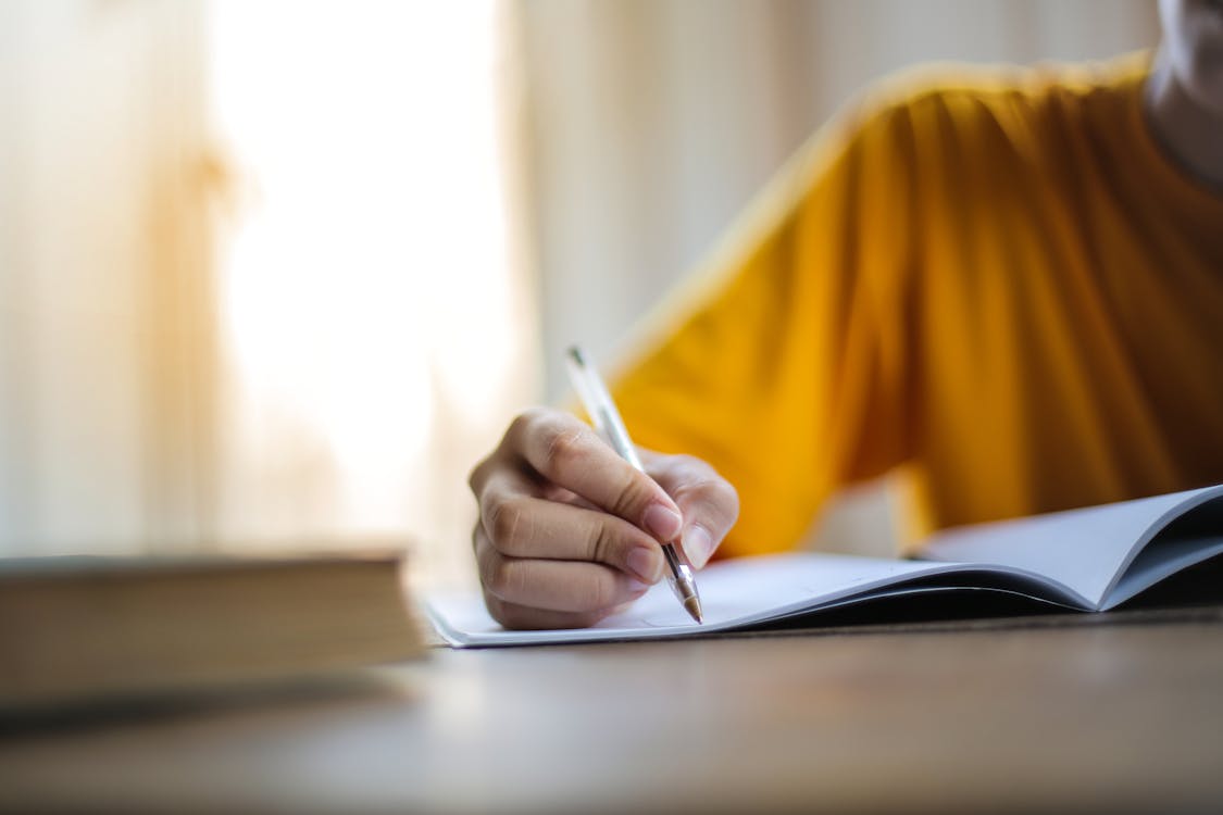 Free Selective Focus Photo of Person Writing Stock Photo