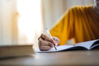 Close-up of a person writing in a notebook — photo by Andrea Piacquadio on Pexels