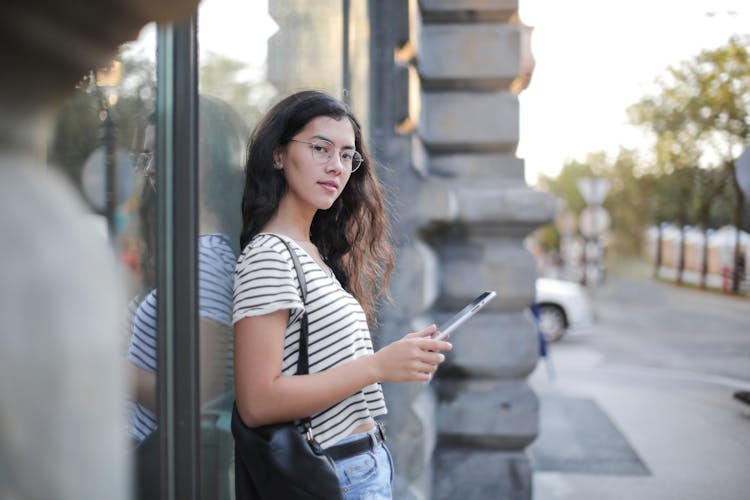 Young Female Using Tablet On City Street