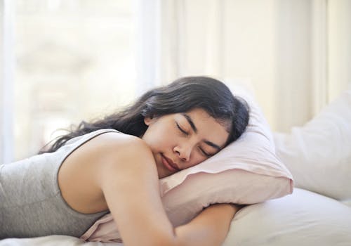 Femme En Débardeur Gris Allongé Sur Le Lit