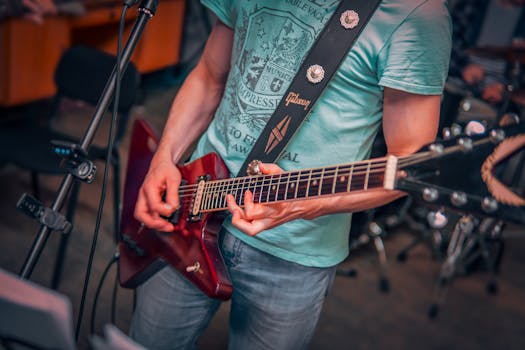 Close-up of guitarist's hands strumming an electric guitar during a performance indoors.