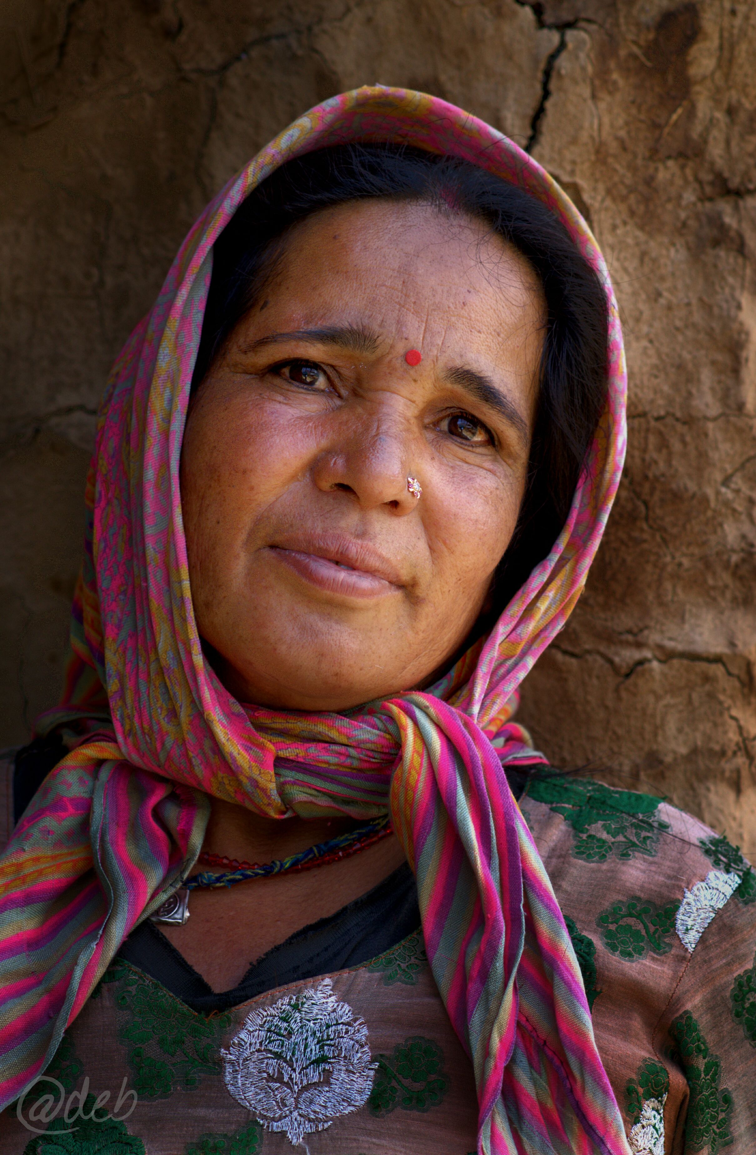 Woman sitting at her desk looking drowsy and rubbing her temples in the early afternoon