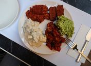 A mixed appetizer plate featuring various dips and dishes in a restaurant setting, perfect for a culinary experience.