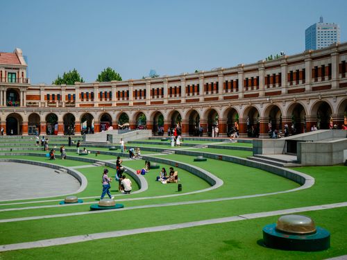 Free People enjoy a sunny day at a modern amphitheater with circular seating and elegant arches. Stock Photo