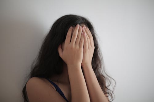 Free Woman Covering Her Face With Her Hands Stock Photo