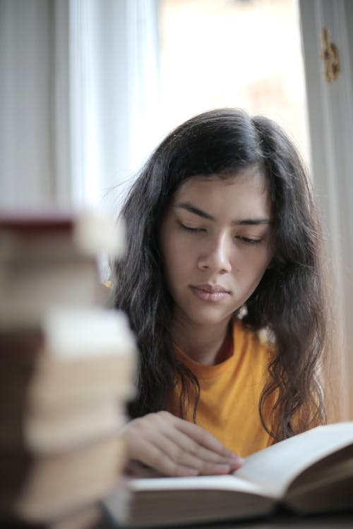 Free Woman in Yellow Shirt Reading a Book Stock Photo