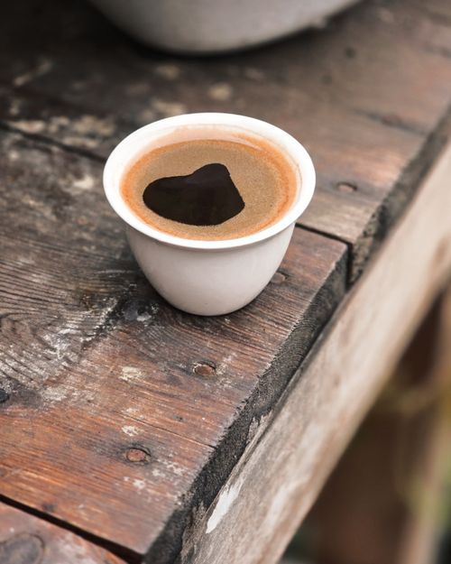 Free Cup of coffee with heart reflection on a rustic wooden table, perfect for romantic themes. Stock Photo