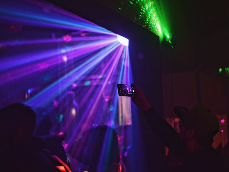 People Dancing In Nightclub With Neon Light