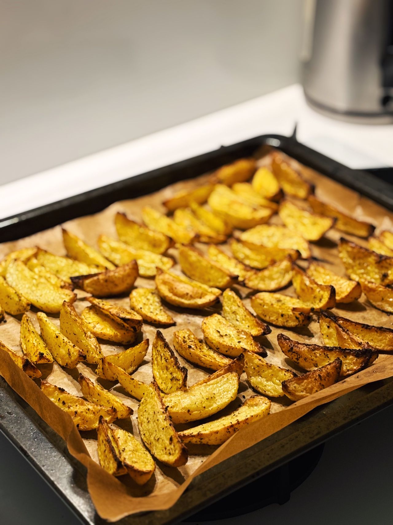 Crispy baked potato wedges on a parchment-lined tray