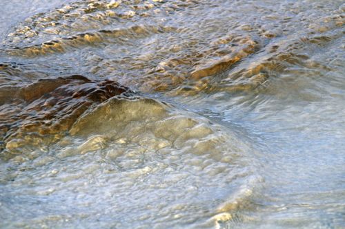 Free Close-up of sea waves flowing over stones at Guaratuba Beach, Paraná, Brazil. Stock Photo