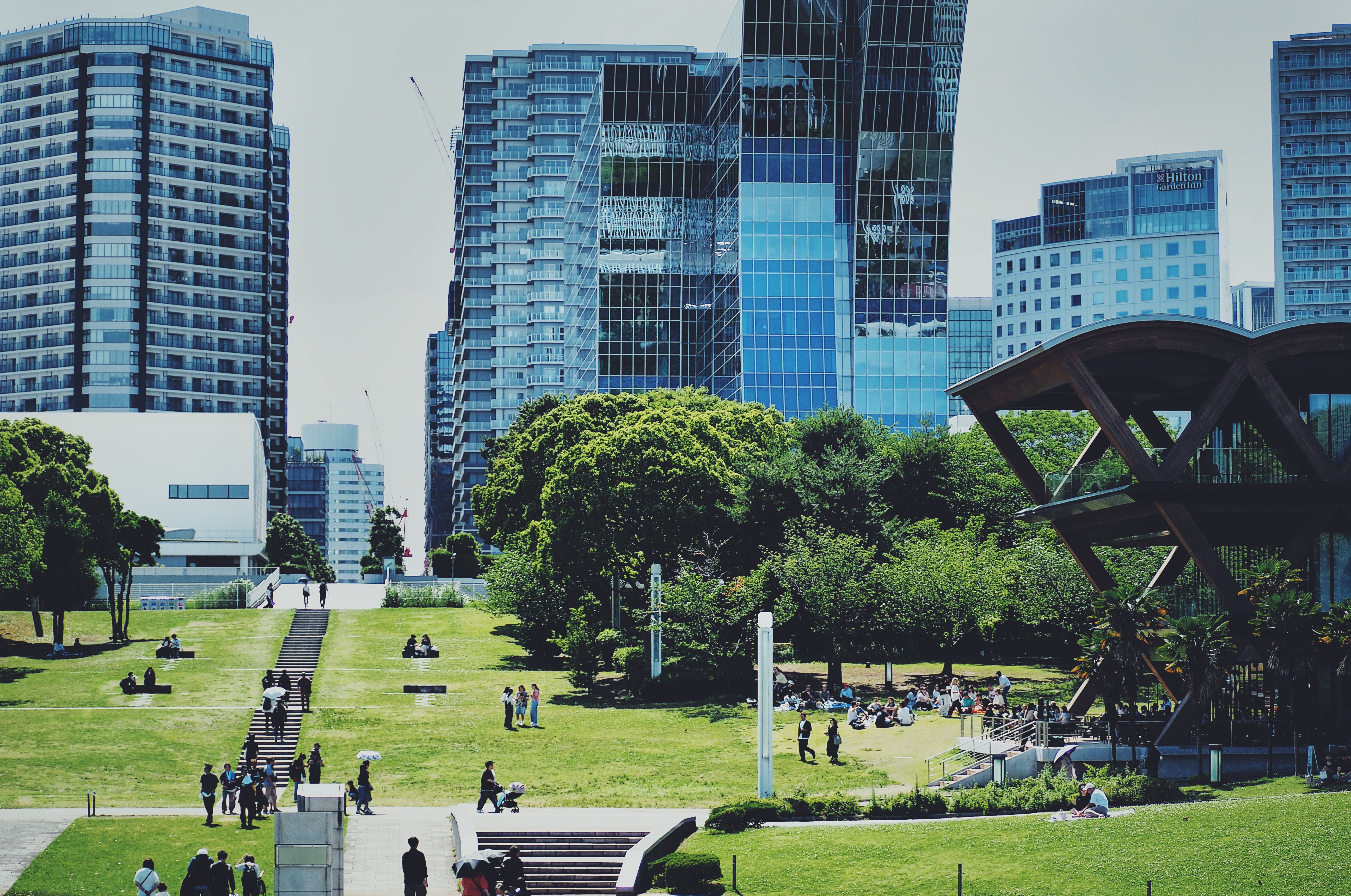 日本の横浜にある、未来的な建物が立ち並ぶ活気あふれる都市公園。