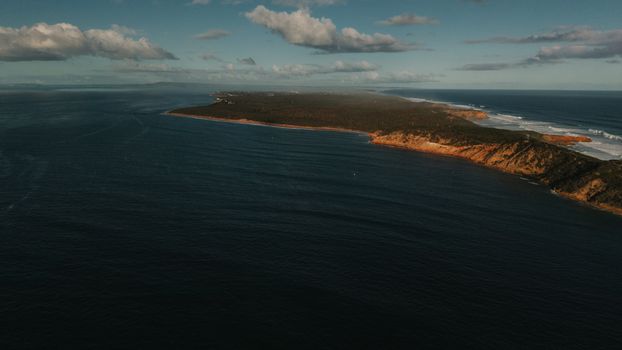 A breathtaking aerial view of the rugged coastline of Portsea, Victoria, Australia, bathed in sunlight.