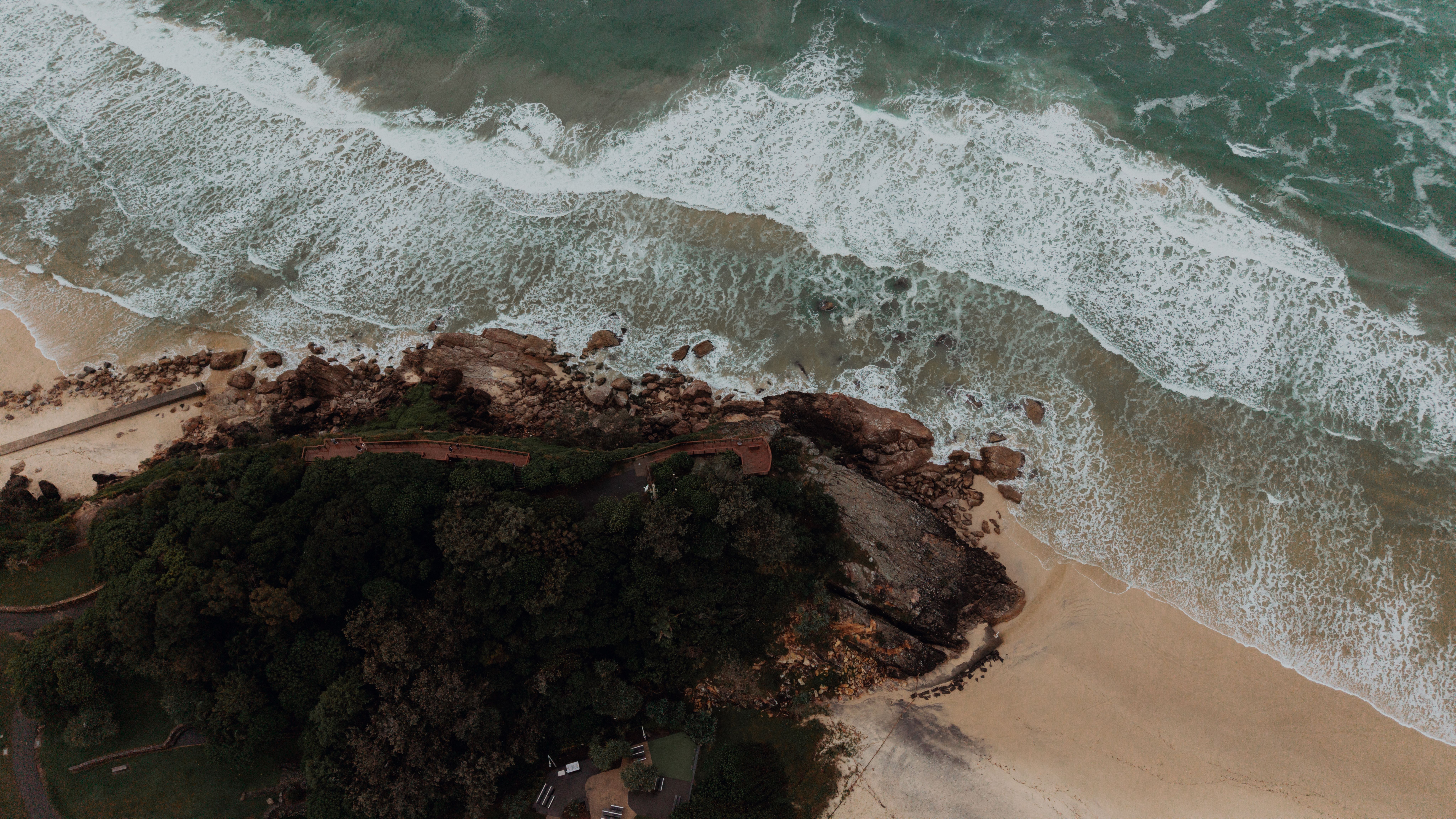 Stunning aerial shot of Burleigh Heads beach in Gold Coast, Australia, showcasing waves crashing on the shore.