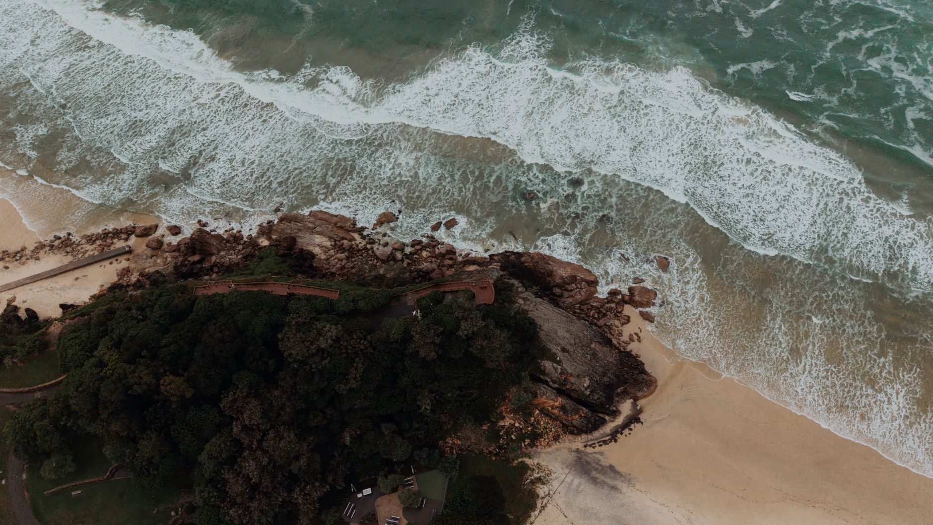Stunning aerial shot of Burleigh Heads beach in Gold Coast, Australia, showcasing waves crashing on the shore.
