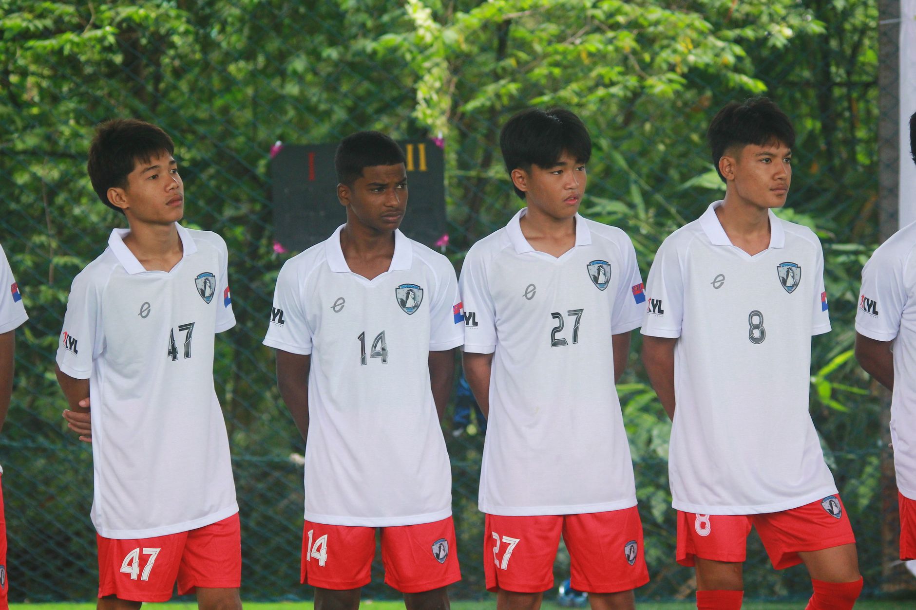 Four soccer players in uniform standing outdoors, ready for a match in Myawaddy, Myanmar.