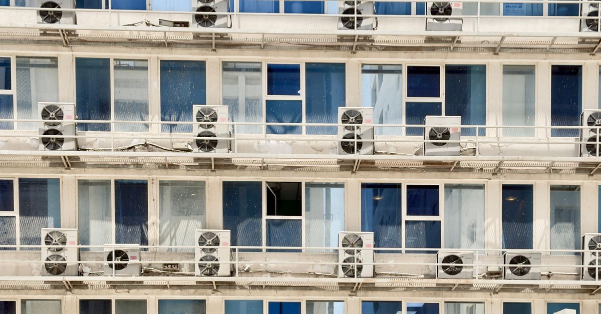 Close-up of modern building exterior with air conditioners on every floor.